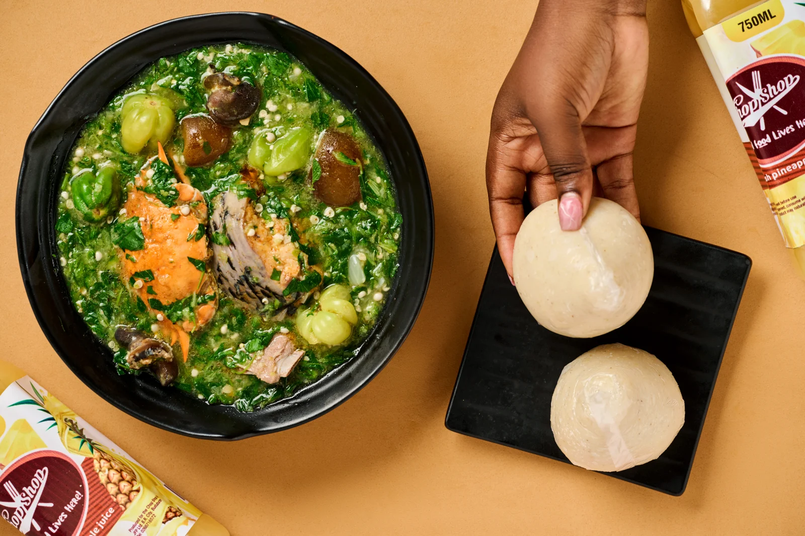 A bowl of ChopShop okro stew beside banku being served